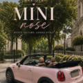 Mini décapotable rose brillante garée sur une route ensoleillée